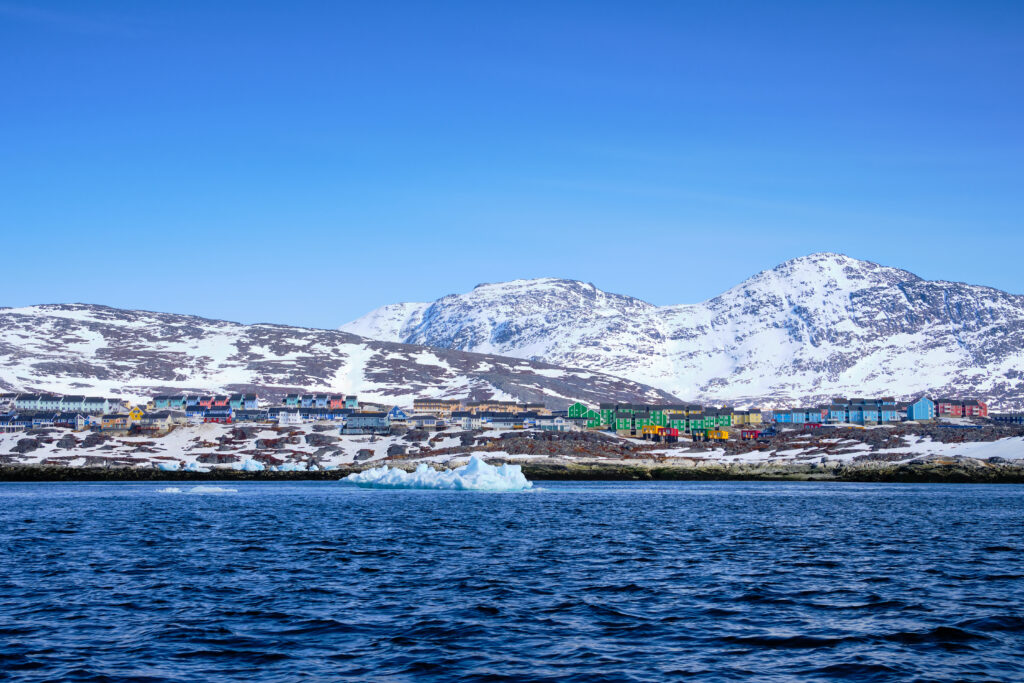 Colorful houses of Nuuk with Lille and Store Malene in the background as seen from a boat tour with Guide to Greenland