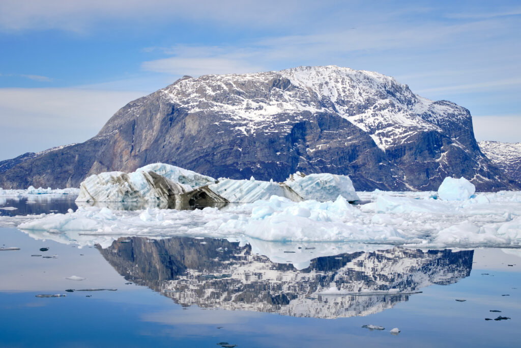 Mountain at the entrance to the Nuuk Icefjord and icebergs reflected in the water on a boat tour with Guide to Greenland