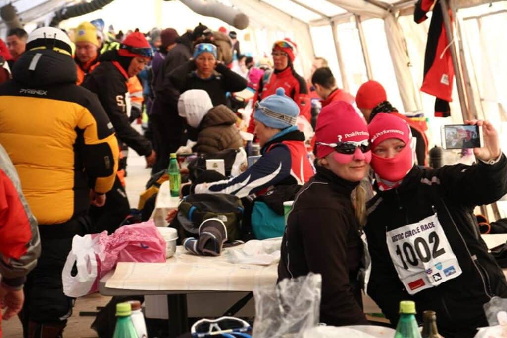 Participants sitting in a large, white tent during Arctic Circle Race