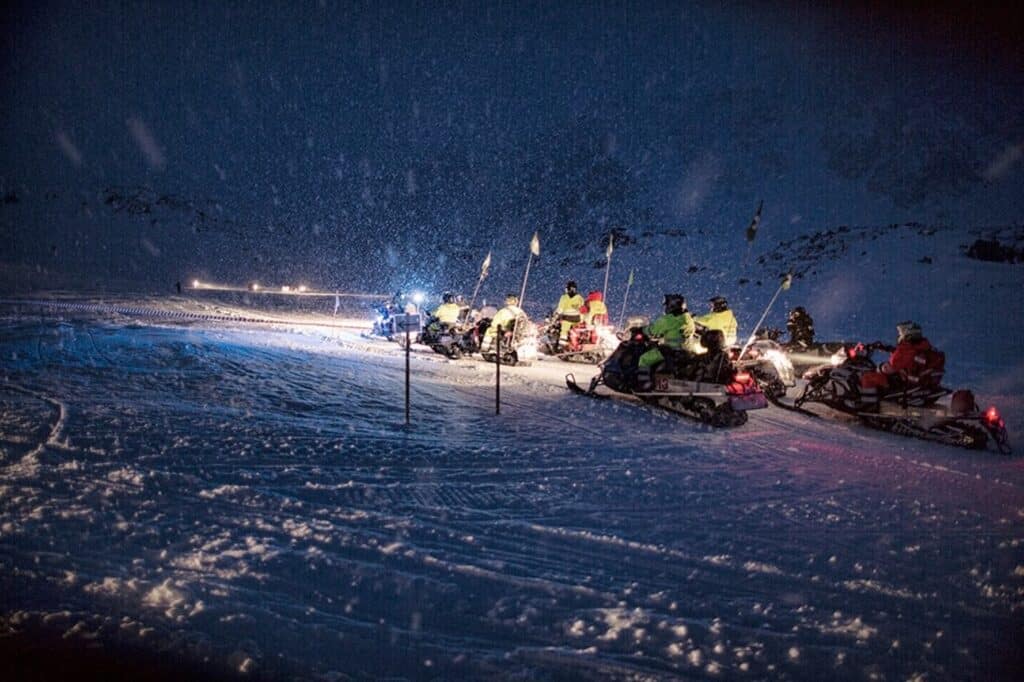 People on snowmobiles during a snowstorm