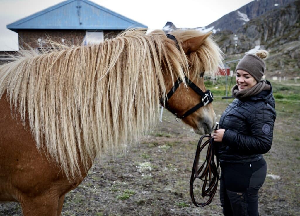 Woman talking to a brown horse