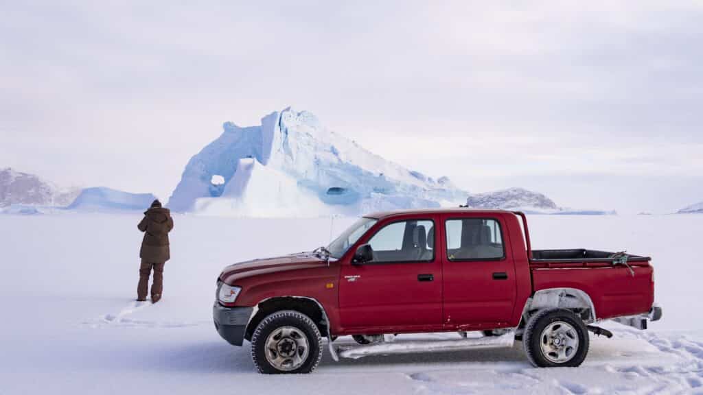 Red car and a man on the sea ice