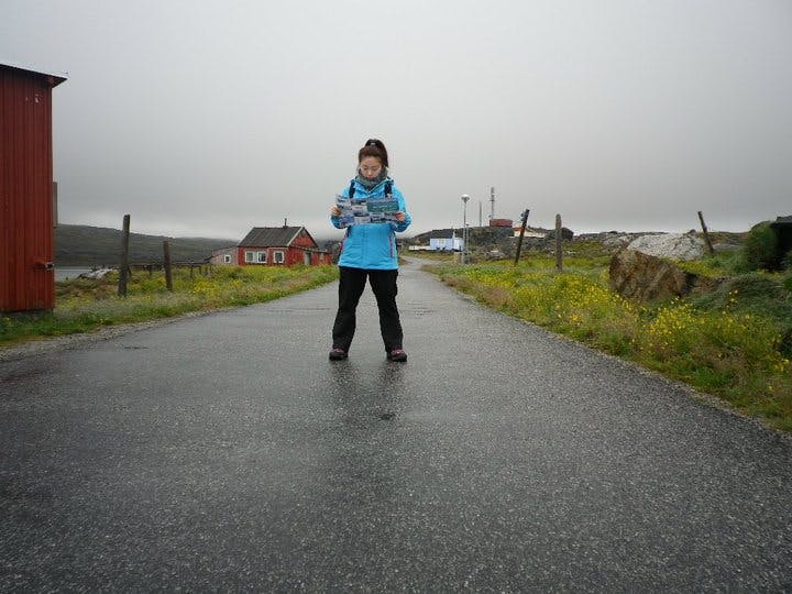 Woman in blue coat standing in the middle of the road