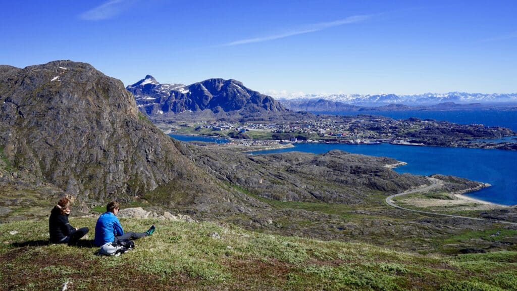 Man and woman looking towards Sisimiut from a mountain top