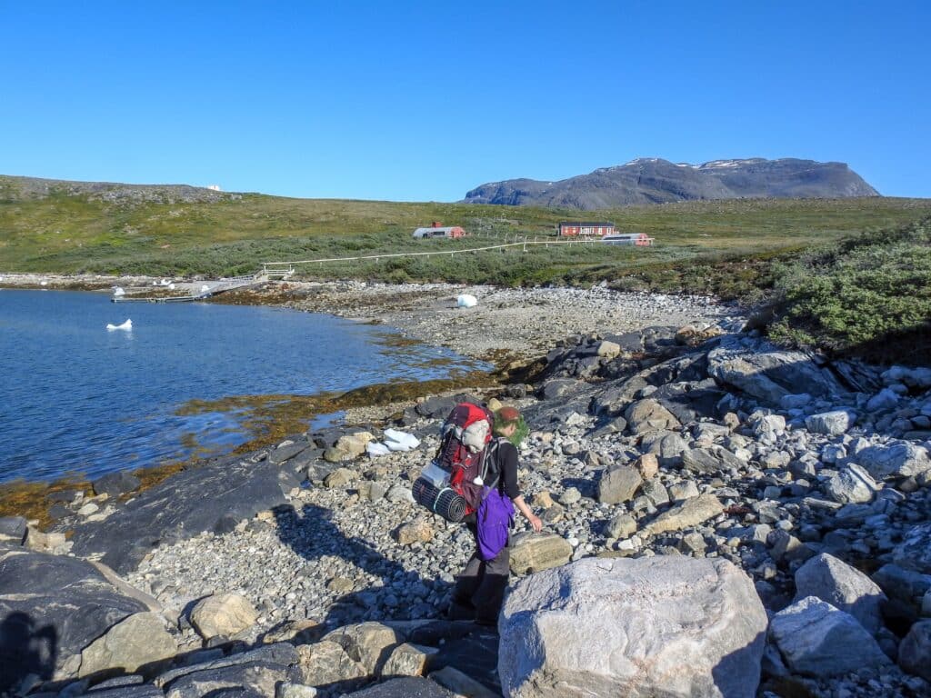Hiker walking on the beach with her large bag