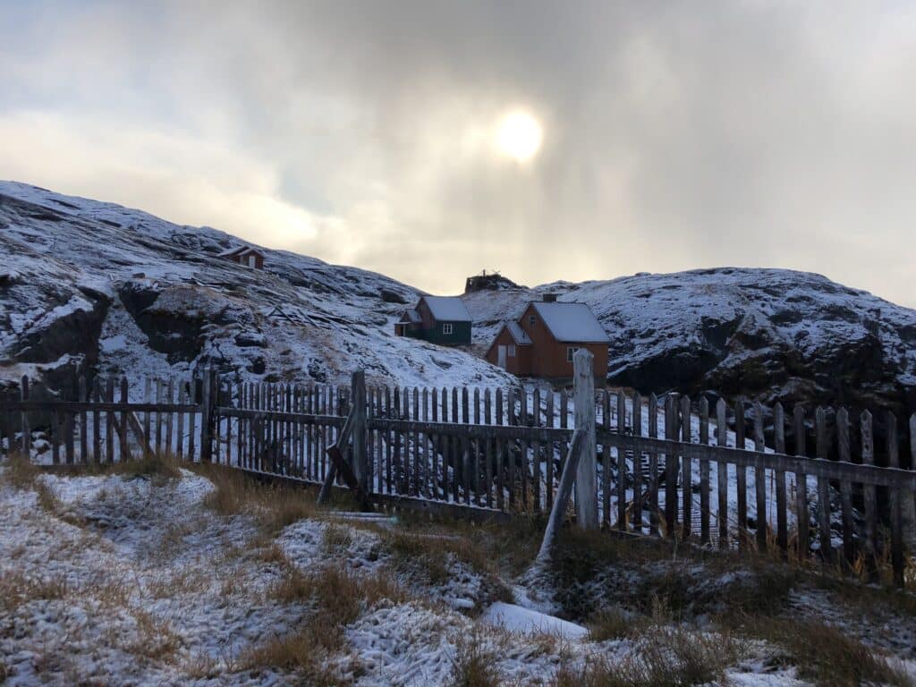 Sun shining down upon houses in the abandoned settlement of Kangeq
