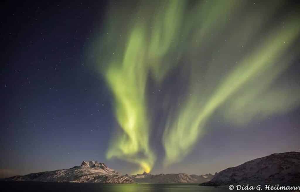 Northern lights over snow covered mountains