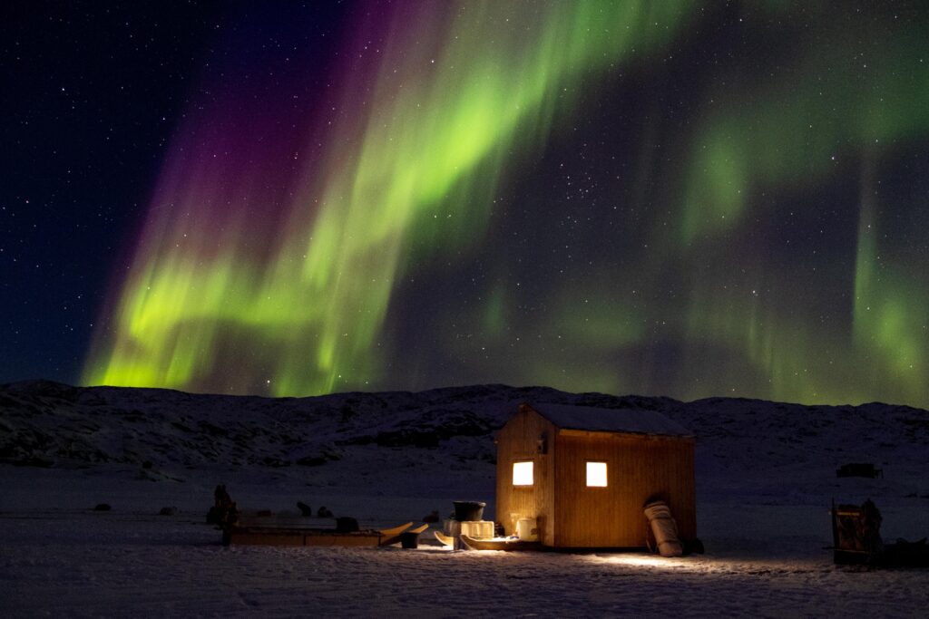 Nordlys over en lille hytte nær Uummannatsiaq ved Uummannaq