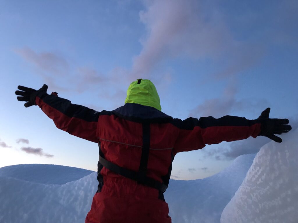 Woman posing for a picture in front of an iceberg