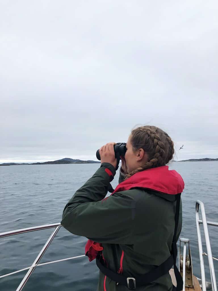 Girl looking out for puffins on the island outside Nuuk