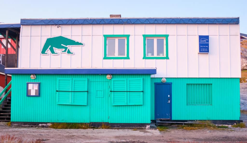 Restaurant Nanoq, Nanuaraq bar, and the disco are all contained within this green, blue, and white building