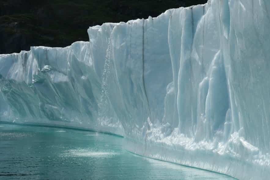 Enormous icebergs with a small waterfall in the South of Greenland