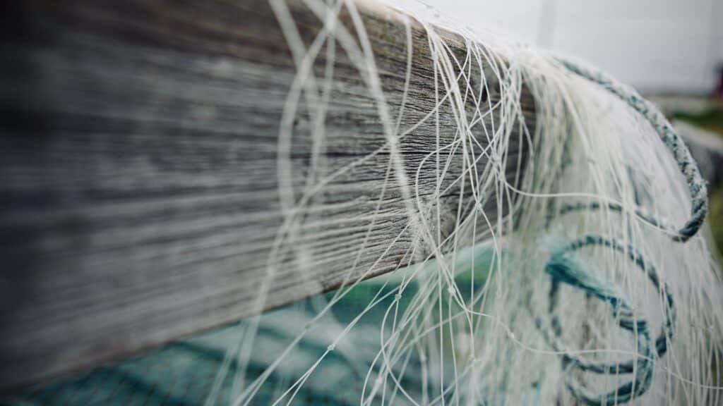 Fishing net hanging over a plank