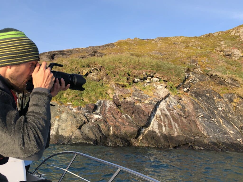 Man taking pictures of puffins