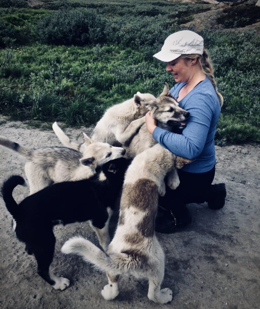 Woman cuddling the sled dog puppies