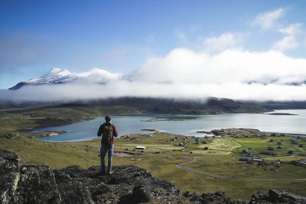 Man looking over the fjord and mountians