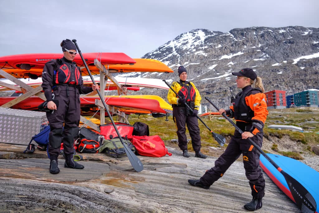 Guide giving an explanation of how to adjust the paddle on a stand-up paddleboarding tour in Nuuk - Guide to Greenland