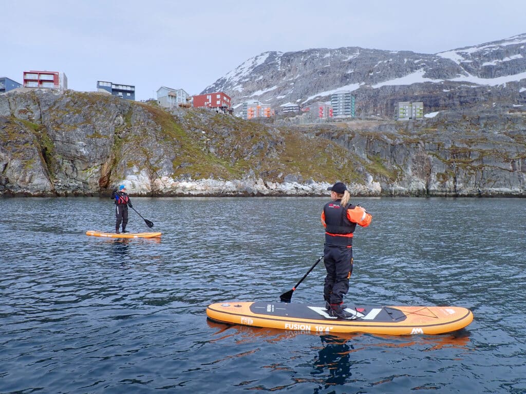 Paddling past the apartments of Nuuk and Ukkusissat - store malene -on a stand-up paddleboarding tour - Guide to Greenland