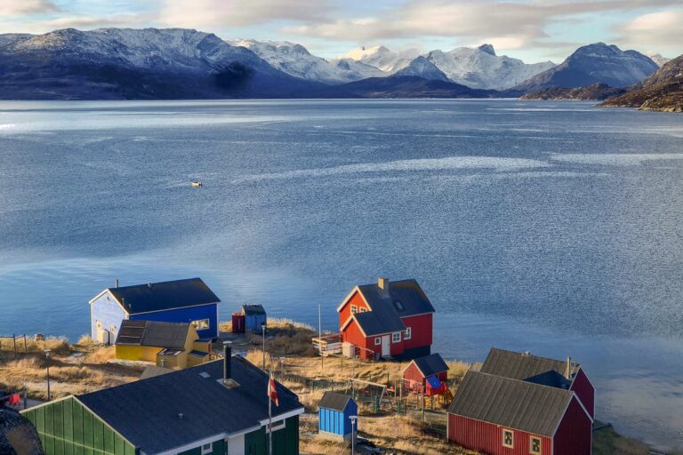View over the colorful houses of Kapisillit looking out into the fjord - summer - Guide to Greenland
