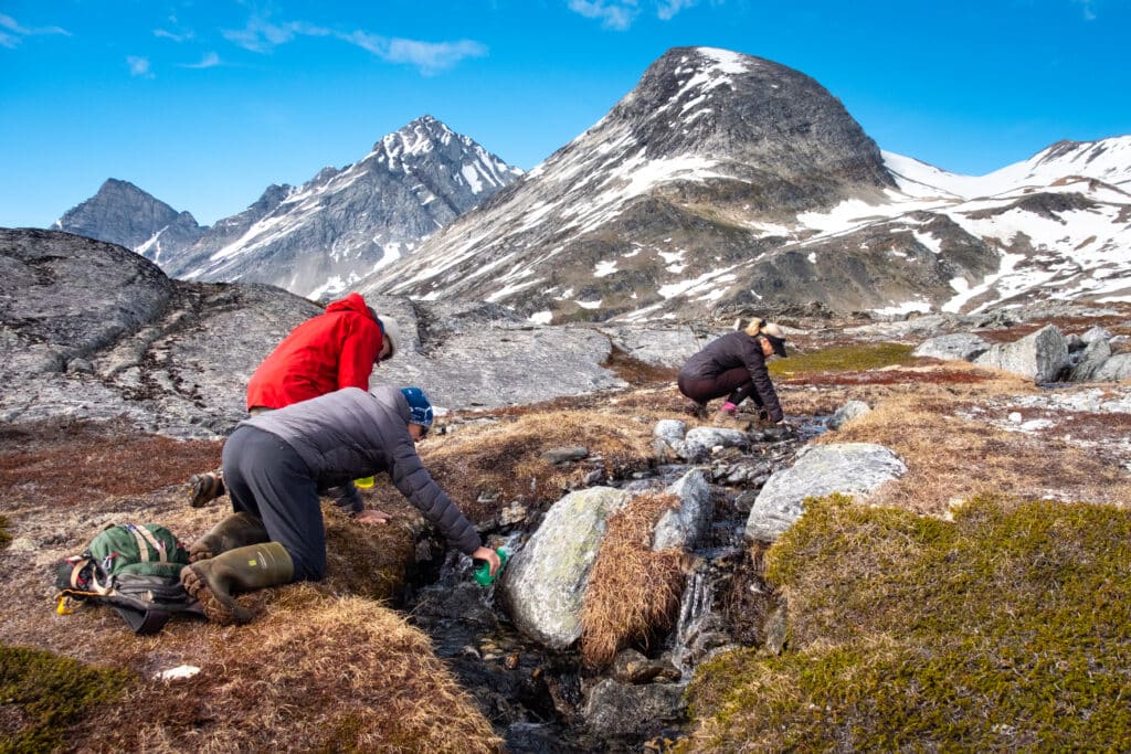 Genopfyldning af vandflasker på en vandretur nær Kuummiut i Østgrønland
