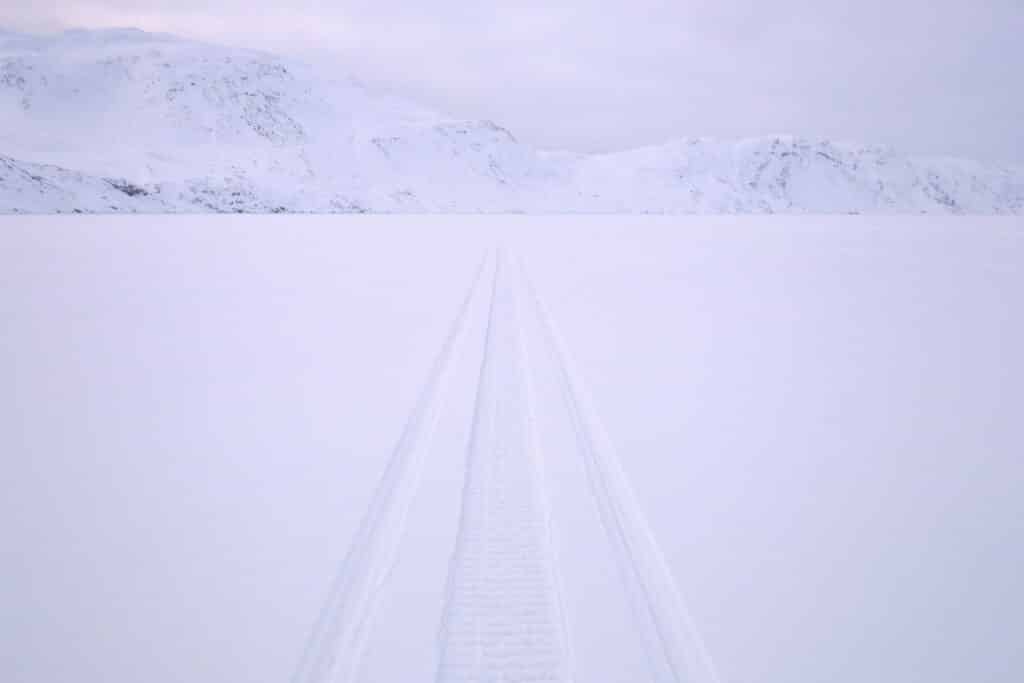 Snowmobile tracks across the frozen Kangerlusarsuk Tulleq fjord near Sisimiut